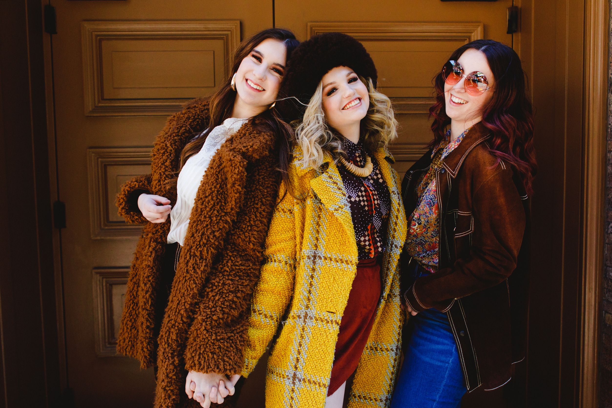 Three models laughing, wearing vintage winter fashion in New York City