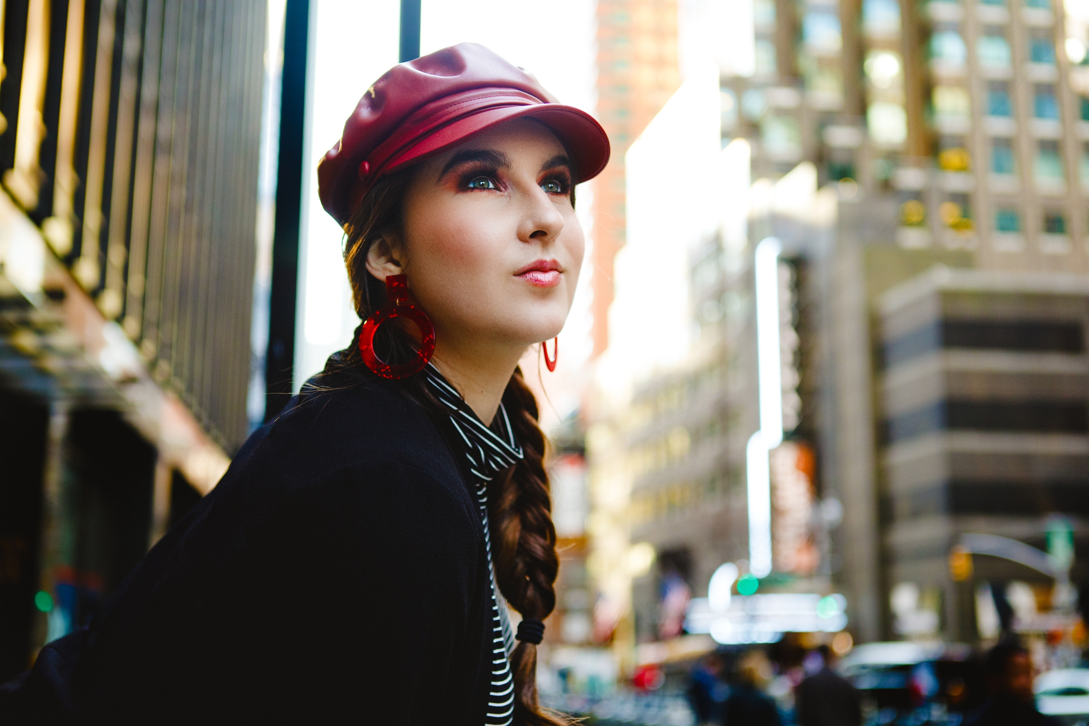 Model in New York City wearing red cap and large red earrings
